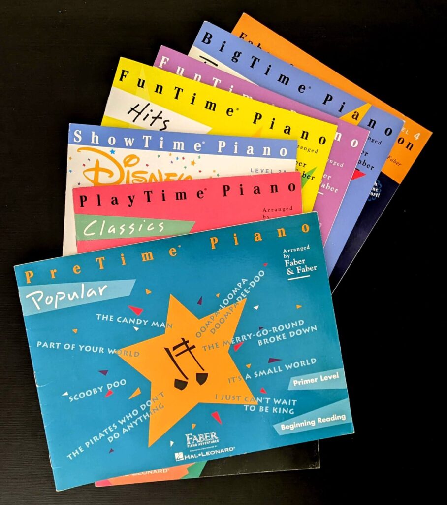 a colorful spread of Faber Piano Adventures supplemental piano books arranged against a black background